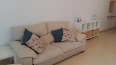 a couch with pillows on it in a living room at El apartamento de Marina en Moncofar playa in Moncófar