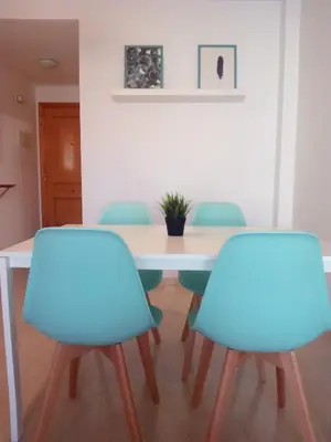 a table with four blue chairs in a room at El apartamento de Marina en Moncofar playa in Moncófar