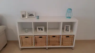 a white shelf with three pictures and baskets at El apartamento de Marina en Moncofar playa in Moncófar