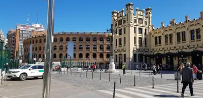 a group of people walking in a city with a building at Edificio Tiziano Mercado Central in Valencia