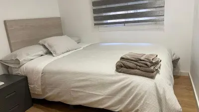 a bed in a bedroom with a blanket on it at Edificio Tiziano Mercado Central in Valencia