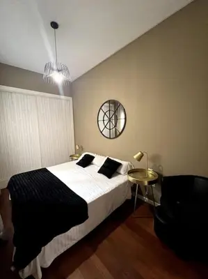 a bedroom with a bed and a table with a chair at San Vicente in Valencia