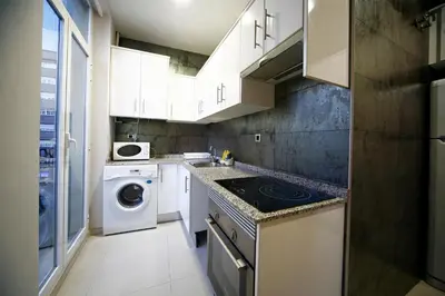a kitchen with a washing machine and a washer and dryer at RealRent Marina Real in Valencia