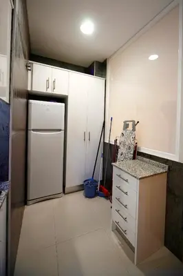 a kitchen with white cabinets and a white refrigerator at RealRent Marina Real in Valencia