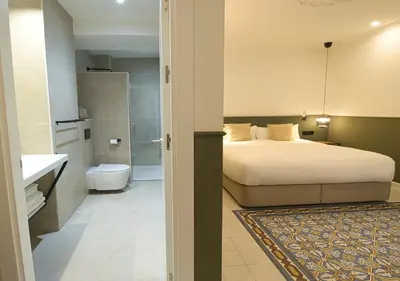 a bedroom with a bed and a bathroom at VALOLA Boutique Rooms in Valencia