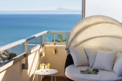 a couch on a balcony with a view of the ocean at 4-Seasons Penthouse Cullera in Cullera