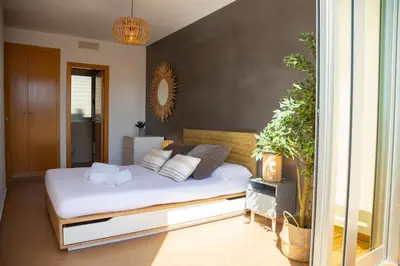a bedroom with a bed with white sheets and pillows at 4-Seasons Penthouse Cullera in Cullera