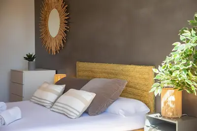 a bedroom with a bed with pillows and a mirror at 4-Seasons Penthouse Cullera in Cullera