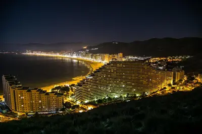 a view of a hotel and a beach at night at 4-Seasons Penthouse Cullera in Cullera