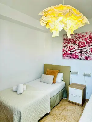 two beds in a room with a painting on the wall at Travel Habitat Jardines de Viveros in Valencia