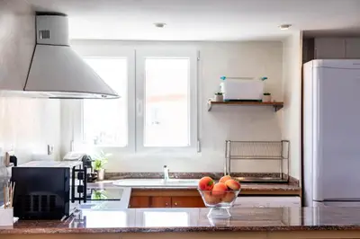 a kitchen with a bowl of fruit on a counter at Travel Habitat Jardines de Viveros in Valencia