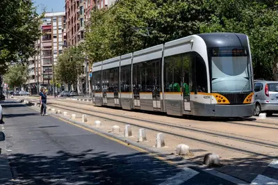 a bus is driving down a city street at Travel Habitat Jardines de Viveros in Valencia