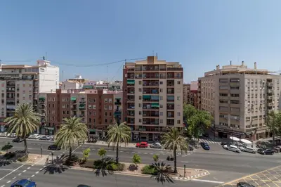 a city with tall buildings and a parking lot with palm trees at Travel Habitat Jardines de Viveros in Valencia