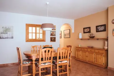 a kitchen and dining room with a wooden table and chairs at Avinguda Mare Nostrum, 101 in Moncófar