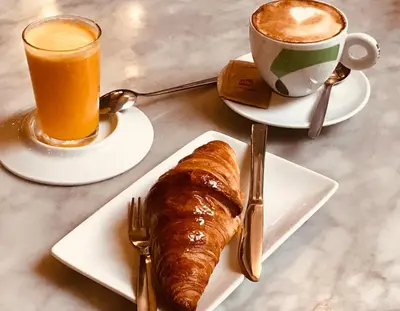 a table with two plates of food and a cup of coffee at Cozy apartment in Valencia center in Valencia