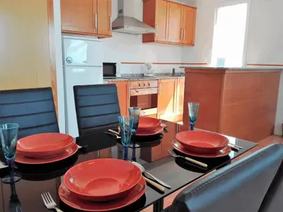 a kitchen with a table with red plates on it at Apartamentos Concha del Mar in Sagunto