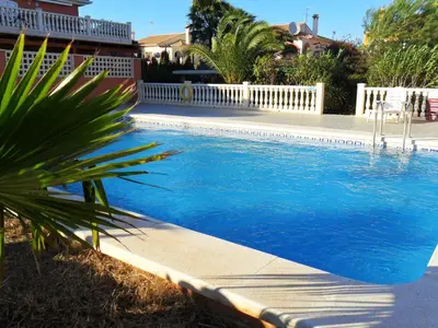 a swimming pool with blue water in a yard at Apartamentos Concha del Mar in Sagunto
