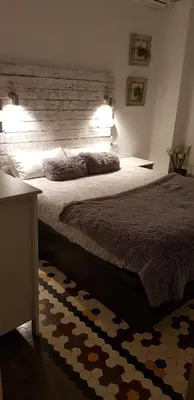 a bedroom with a large bed with a wooden headboard at Domus Valencia Apartamentos centro frente a Torres de Serrano in Valencia
