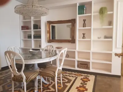 a dining room with a table and chairs and a mirror at Domus Valencia Apartamentos centro frente a Torres de Serrano in Valencia