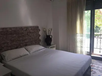 a bedroom with a white bed with a brick wall at Domus Valencia Apartamentos centro frente a Torres de Serrano in Valencia
