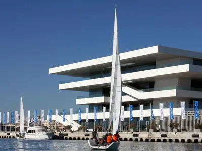 a boat in the water in front of a building at Apartamento con vistas a la Marina Real in Valencia