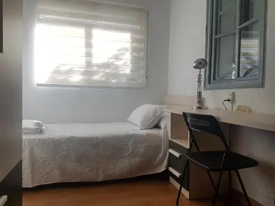 a small bedroom with a bed and a window at Apartamento con vistas a la Marina Real in Valencia