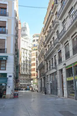 an empty street in a city with tall buildings at Cool Central Market in Valencia