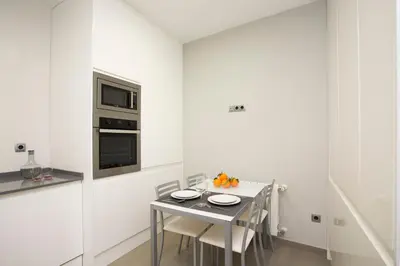 a kitchen with a table with chairs and a microwave at SingularStays Santa Clara in Valencia