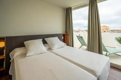 a bedroom with a large bed and a balcony at Teide Rooms in Puerto de Sagunto