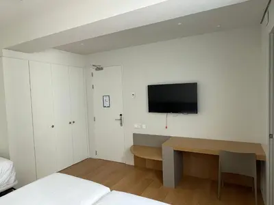 a bedroom with a desk and a tv on the wall at Teide Rooms in Puerto de Sagunto