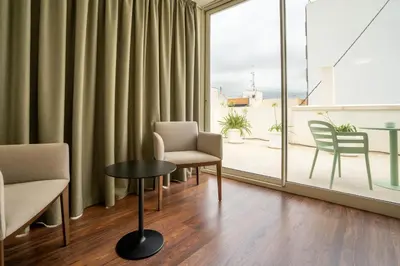 a room with a table and chairs and a large window at Teide Rooms in Puerto de Sagunto