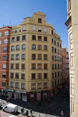 a large yellow building with people walking in front of it at Russafa Youth Hostel in Valencia