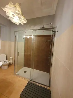 a glass shower in a bathroom with a toilet at Russafa Youth Hostel in Valencia