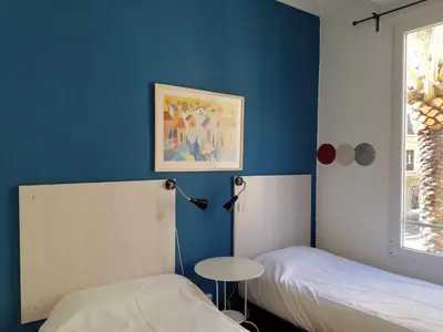 a room with two beds and a table and a window at Russafa Youth Hostel in Valencia