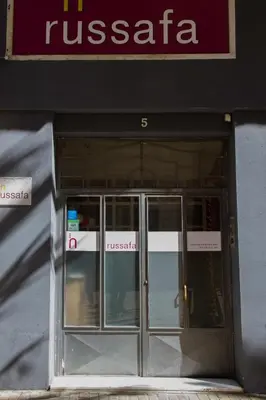 a front door of a tusca store with a sign above it at Russafa Youth Hostel in Valencia
