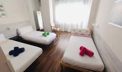 a room with three beds with red and blue pillows at Mar & City Apartment in Valencia