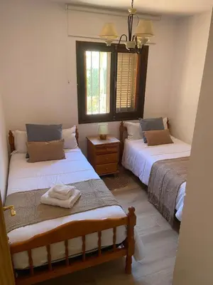 a bedroom with two beds and a window at Precioso chalet en la playa de Tavernes de la Valldigna in Tavernes de Valldigna