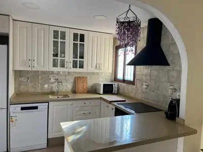 a kitchen with white cabinets and a counter top at Precioso chalet en la playa de Tavernes de la Valldigna in Tavernes de Valldigna