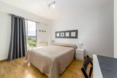 a white bedroom with a bed and a window at Travel Habitat Palau De Les Arts in Valencia