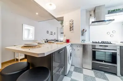 a kitchen with a counter and stools in it at Travel Habitat Palau De Les Arts in Valencia