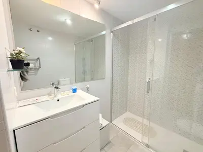 a white bathroom with a shower and a sink at Travel Habitat Palau De Les Arts in Valencia