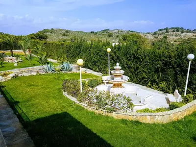 a garden with a fountain in the grass at El Collado in Cullera