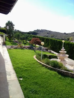 a park with a fountain in the grass at El Collado in Cullera