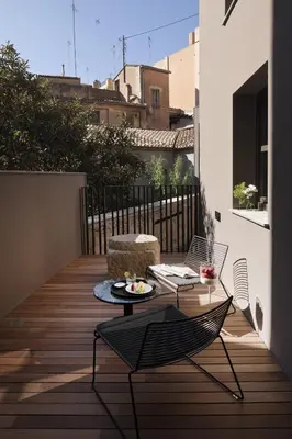 a patio with a table and chairs on a balcony at Caro Hotel in Valencia