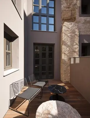 a patio with two benches and a table at Caro Hotel in Valencia