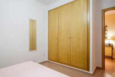 a bedroom with a bed and a wooden cabinet at Apartamento Cerca De Valencia in Riba-Roja De Turia