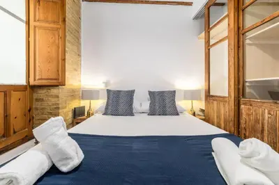 a bedroom with a large bed with blue sheets and pillows at My Loft 4 You Temple in Valencia