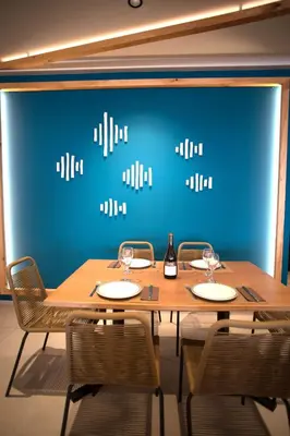 a wooden table with chairs and a blue wall at El Chalet in Cullera