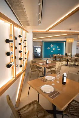 a restaurant with tables and chairs and wine racks at El Chalet in Cullera