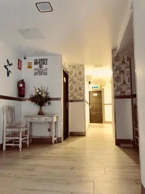 a room with a hallway with a table and a refrigerator at Hostal Boutique Luna de Gavín in Cullera